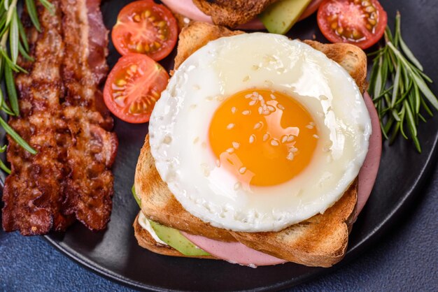 Frische leckere Sandwiches mit gebratenem Ei, Schinkenbutter, Avocado und Sesamsamen