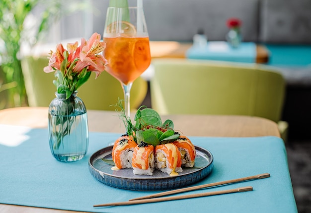 Frische, leckere Sushi-Rollen mit Lachs auf dem servierten Tisch im Restaurant mit einem schönen Blitz