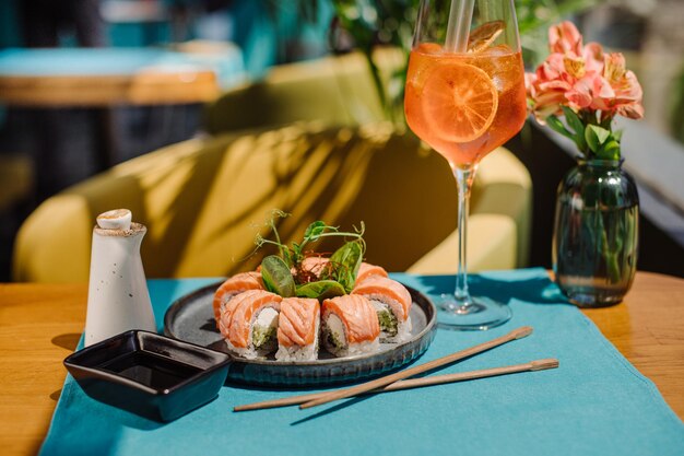 Frische, leckere Sushi-Rollen mit Lachs auf dem servierten Tisch im Restaurant mit einem schönen Blitz