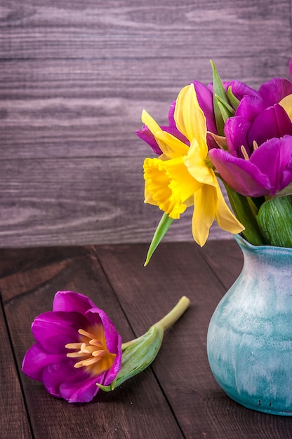 Frische lila Tulpe, gelbe Blumen schließen oben auf Holztisch Bouquet Schneeglöckchen auf Holztisch. Frühlingsblumen.