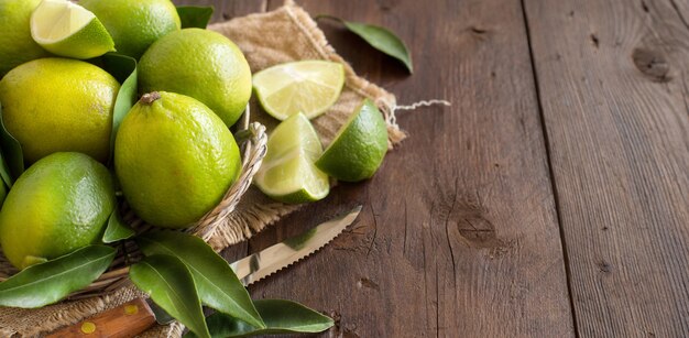 Frische Limetten mit Messer auf einem Holztisch