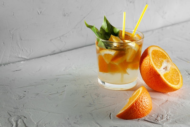 Frische Limonade mit Minze, Orange und Eis im Glas auf dem weißen Hintergrund Kaltes Sommergetränk und Cocktail