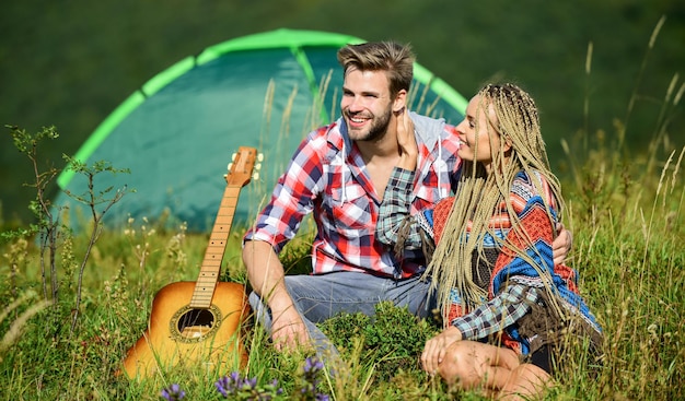 Frische Luft und pure Gefühle. Sommerurlaub. Freund-Freundin-Gitarre in der Nähe von Campingzelt. Campingurlaub. Wanderromantik. Camping in den Bergen. Paare in der Liebe glücklicher entspannender Naturhintergrund.