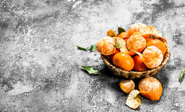 Frische Mandarinen in einem Korb auf einem rustikalen Hintergrund