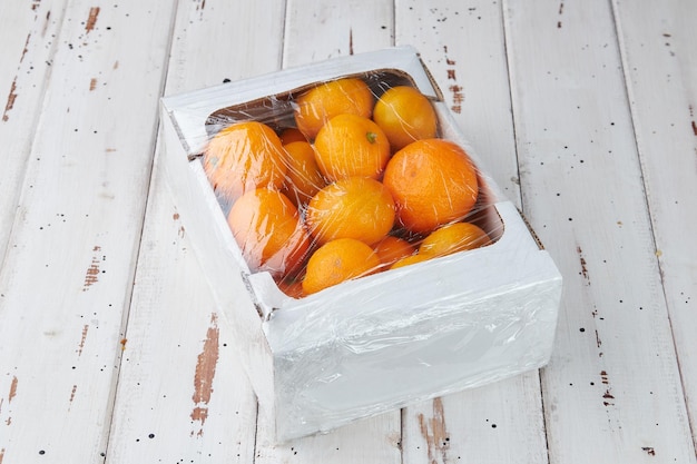 Frische Mandarinen oder Mandarinen mit Blättern auf einem Holztisch