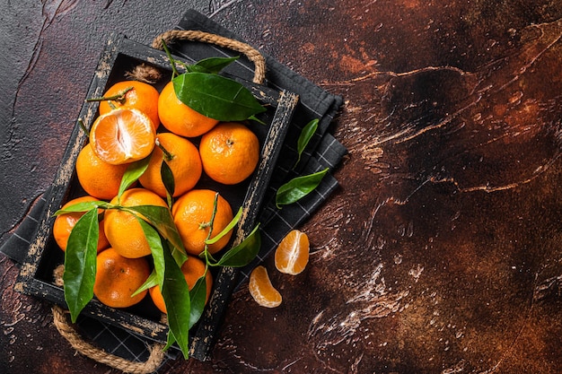 Frische Mandarinen oder Mandarinenfrüchte mit Blättern Dunkler Hintergrund Draufsicht Kopierbereich