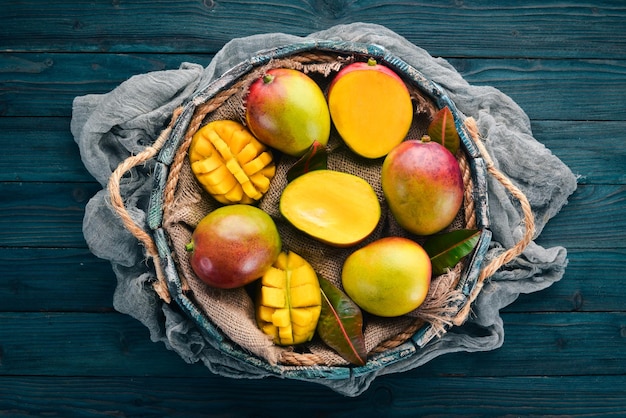 Frische Mango in einer Holzkiste Auf einem hölzernen Hintergrund Tropische Früchte Draufsicht Kostenloser Kopierbereich