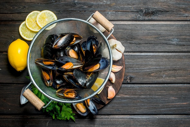 Frische Meeresfrüchte-Muscheln mit Zitronenspalten, Knoblauch und Petersilie