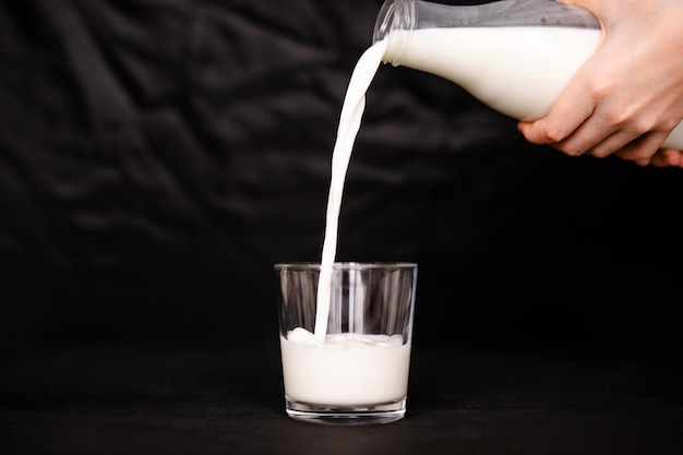 Frische Milch in das Glas gießen