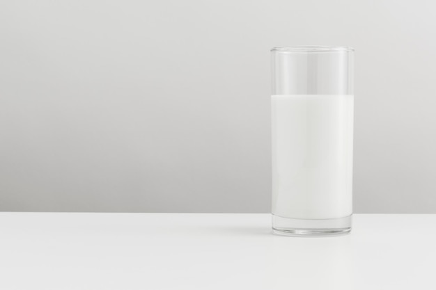 Frische Milch in einem Glas auf einem Tischbanner