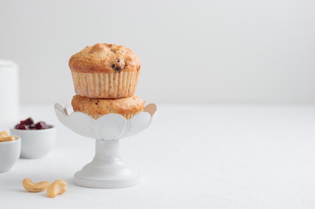 Frische Muffins in einem Cakestand auf einem weißen Tisch