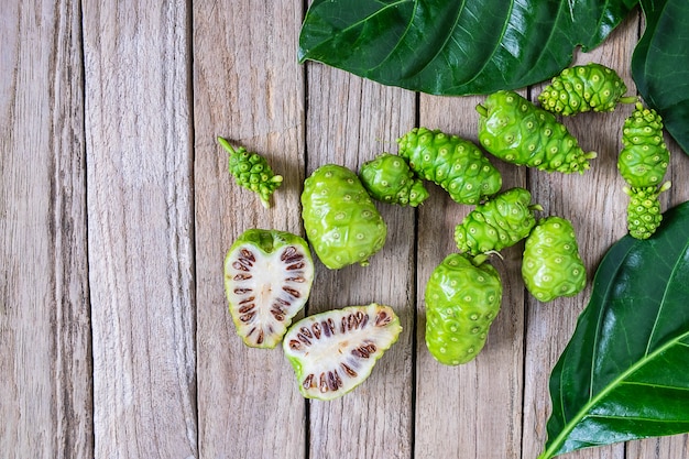 Frische noni-frucht auf einem hölzernen hintergrund