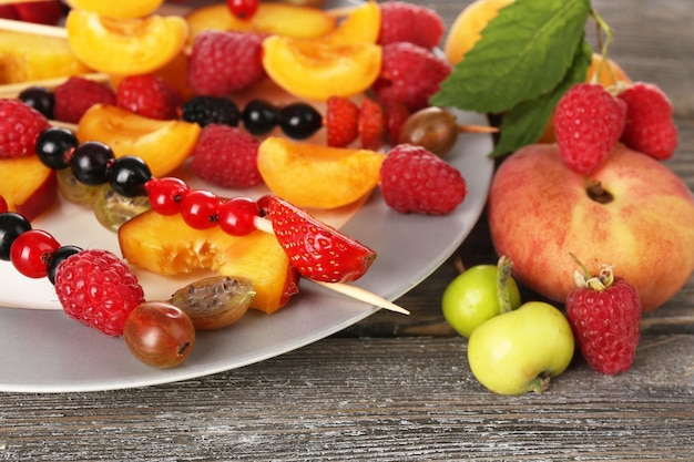 Frische Obstspieße für einen gesunden Snack auf einem Holztisch aus nächster Nähe