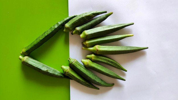 Frische Okra-Schoten auf grün-weißem Hintergrund