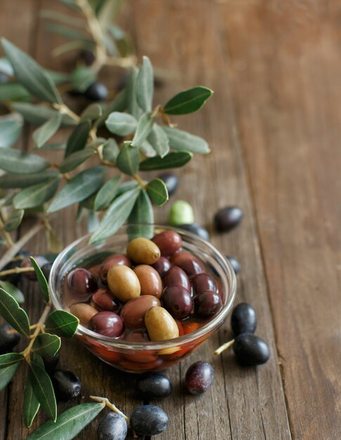 Frische Oliven und Olivenzweig n Holztisch schließen mit Kopienraum