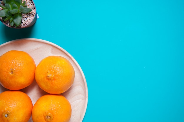 Frische orange Früchte und Saft auf blauer Tabelle.