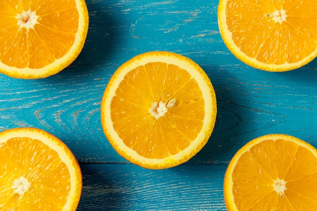 Foto frische orangen, ansicht von oben. gesunde zitrusfrüchte auf blauem hölzernem hintergrund, draufsicht, copyspace.