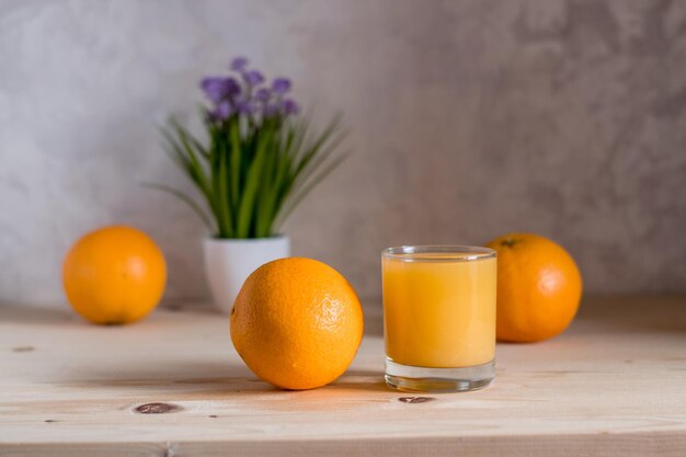 Frische Orangen auf dem Tisch und ein Glas Saft