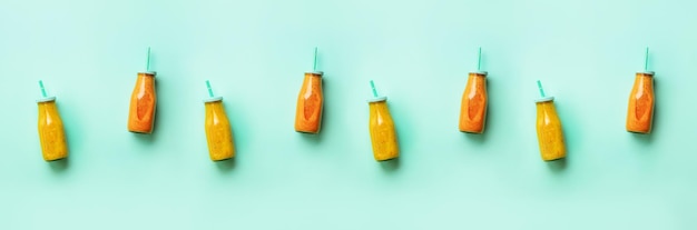 Foto frische orangen-bananen-ananas-mango-smoothies und saftige früchte auf blauem hintergrund banner nahtloses muster detox-sommergetränk vegetarisches konzept ansicht von oben flach liegend kopieren