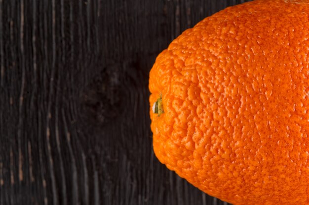 Foto frische orangenfrucht auf dem dunklen holz