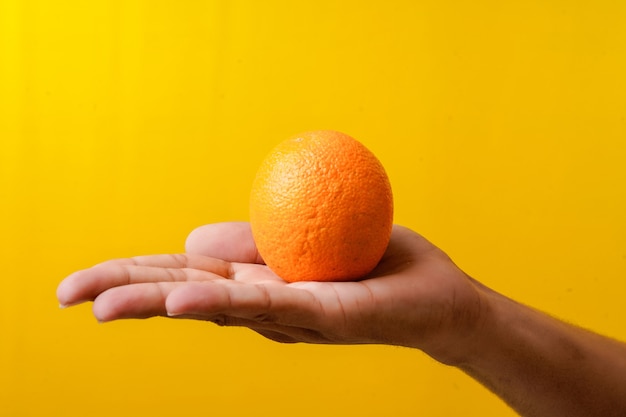 Frische Orangenfrucht in der Hand halten