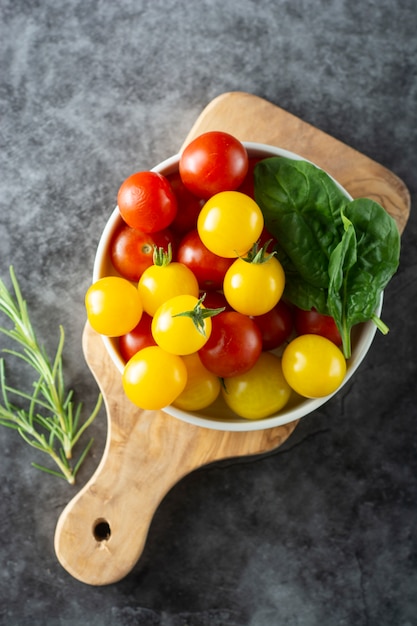 Frische, organische gelbe und rote Tomaten in der Platte