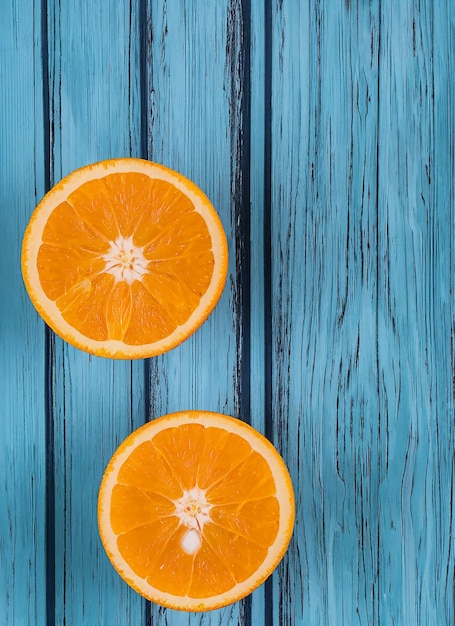 Frische organische Orangen halbieren Früchte auf blauem hölzernen Hintergrund mit Kopierplatz