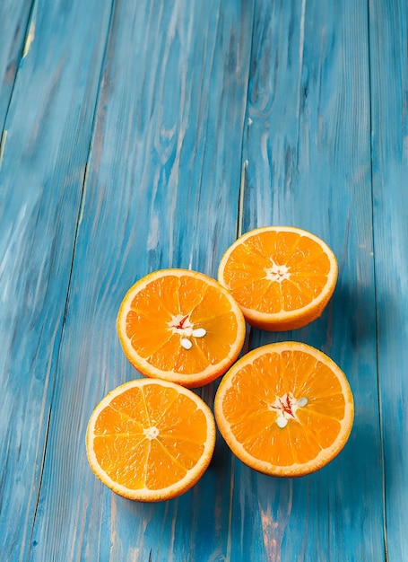 Frische organische Orangen halbieren Früchte auf blauem hölzernen Hintergrund mit Kopierplatz