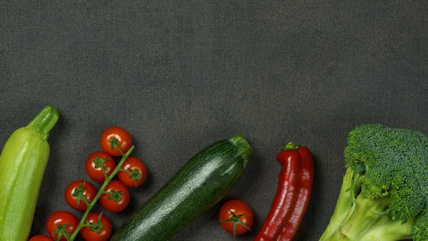Frische organische Zucchini-Brokkoli-Tomatenpaprikaschotennahaufnahme auf einem dunklen Hintergrundrahmen des Gemüses