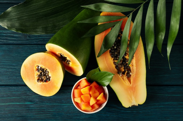 Frische Papaya mit Blättern auf Holztisch, Ansicht von oben