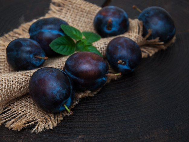 Frische Pflaumen mit grünen Blättern