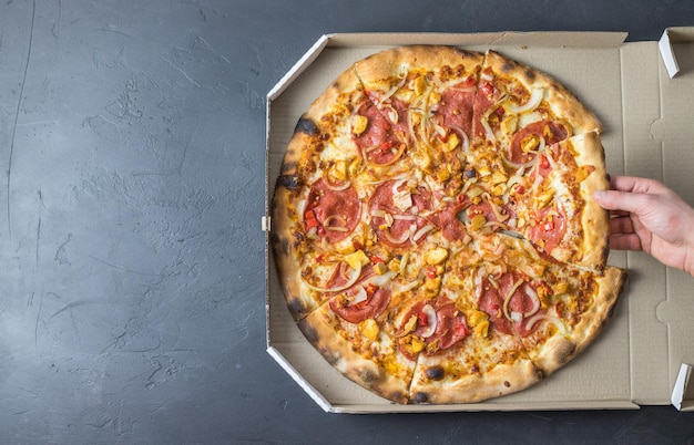 Frische Pizza in einer Schachtel auf dunklem Hintergrund Platz für Text