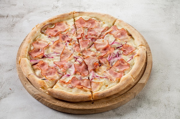 Foto frische pizza mit fleisch und schinken auf dem konkreten hintergrund