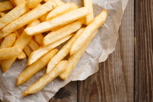 Frische Pommes frites auf Holztischhintergrund