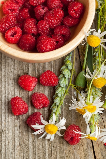 Frische reife Himbeeren und Kamillenblüten