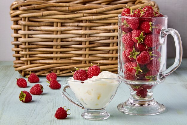 Frische reife Himbeeren und Schlagsahne in einer Glastasse