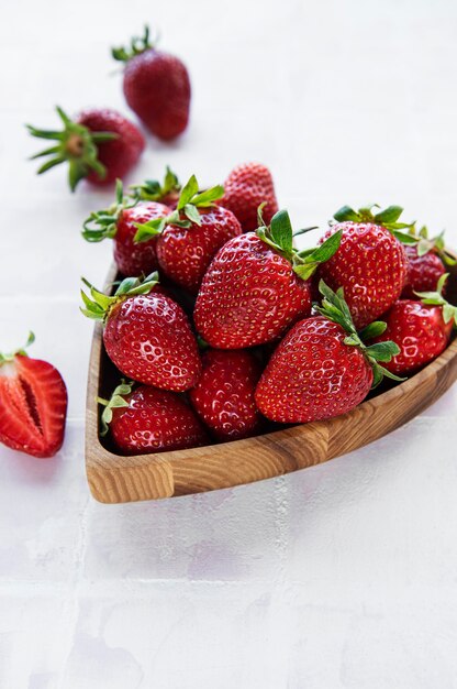 Frische reife köstliche Erdbeeren in einer herzförmigen Holzschale