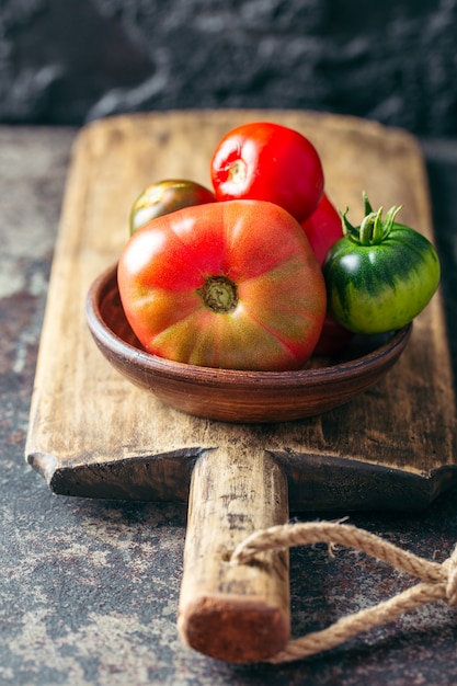 Frische, reife mehrfarbige Tomaten auf einem dunklen Hintergrund.