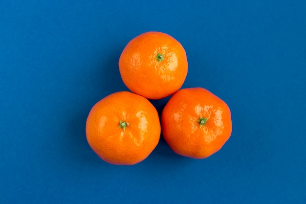 Frische reife orange Mandarinen, Tangerinen auf blauem Hintergrund