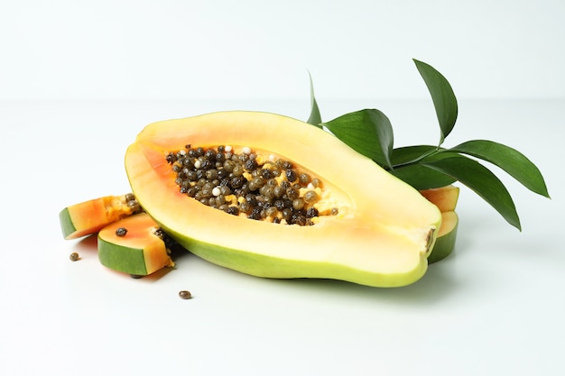 Frische reife Papaya mit Blättern auf weißem Tisch