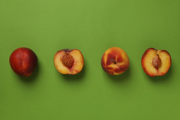Frische reife Pfirsichfrüchte auf grünem Hintergrund