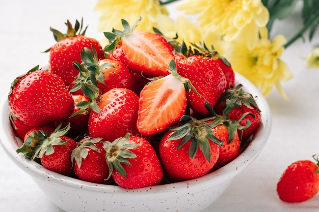 Frische reife saftige Erdbeeren in einer Schüssel auf weißem Hintergrund