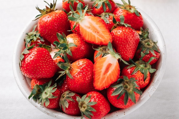 Frische reife saftige Erdbeeren in einer Schüssel auf weißem Hintergrund