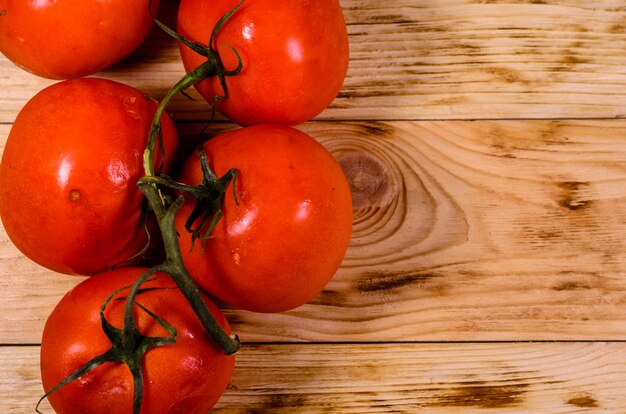 Frische reife Tomaten auf rustikalem Holztisch. Ansicht von oben