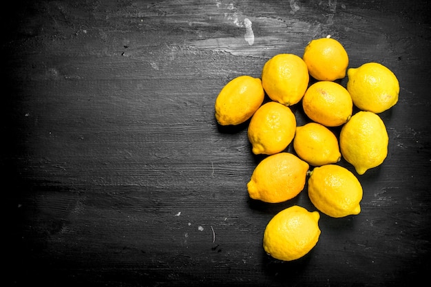 Foto frische reife zitronen. auf der schwarzen tafel.