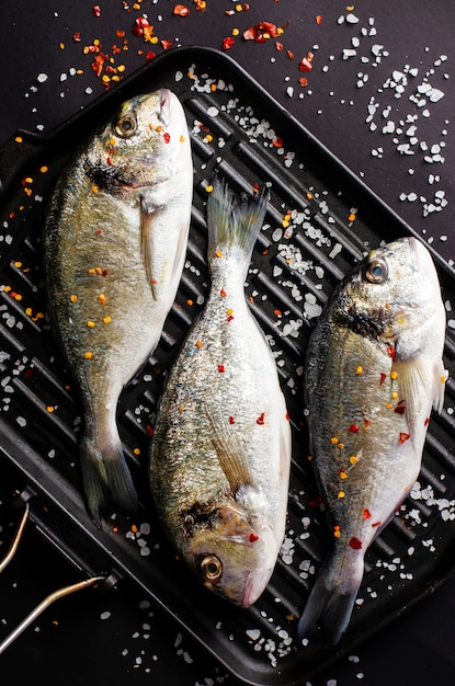 Frische rohe Dorado-Fische auf Eisengrillwanne