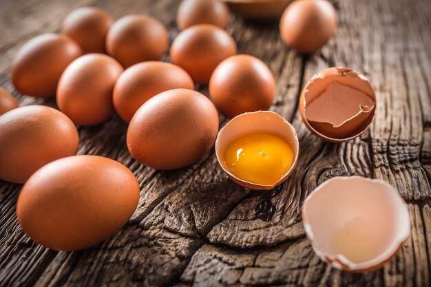 Frische rohe Eier auf rustikalem Holztisch.