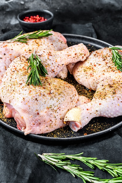 Frische rohe Hähnchenschenkel, Beine auf einem Schneidebrett mit Gewürzen, Kochen.