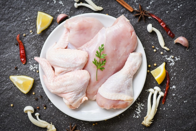 Frische rohe Hühnerbrustflügel und ungekochtes Hühnerfleisch der Beine