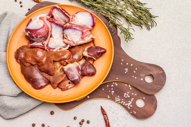 Frische rohe Innereien: Herz, Leber, Magen. Trockene Gewürze, Salz, Chili. Holzschneidebretter,